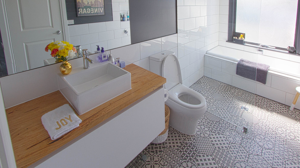 Inspiration för moderna badrum, med vita skåp, vit kakel, keramikplattor, ett fristående handfat och träbänkskiva