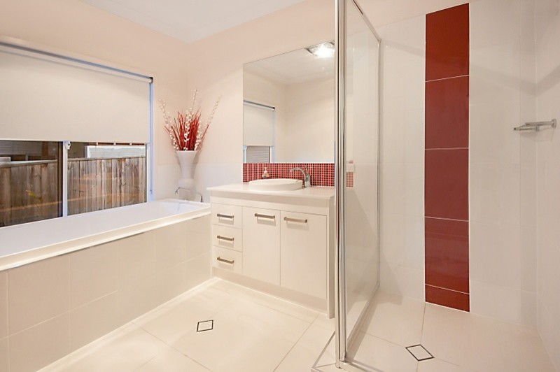 Mid-sized trendy kids' red tile and porcelain tile porcelain tile and white floor bathroom photo in Brisbane with white cabinets, a one-piece toilet, white walls, a drop-in sink, quartz countertops and a hinged shower door
