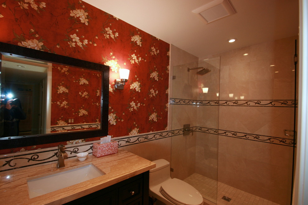 Ispirazione per una stanza da bagno mediterranea con ante in stile shaker, ante in legno bruno, WC monopezzo, piastrelle beige, piastrelle di vetro, pareti rosse, pavimento in marmo, lavabo a bacinella e top in marmo
