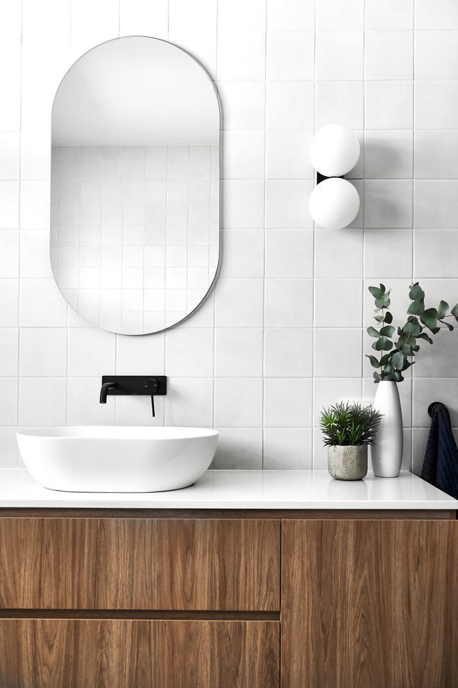 Modernes Badezimmer mit flächenbündigen Schrankfronten, hellbraunen Holzschränken, weißen Fliesen, Aufsatzwaschbecken und weißer Waschtischplatte in Sydney