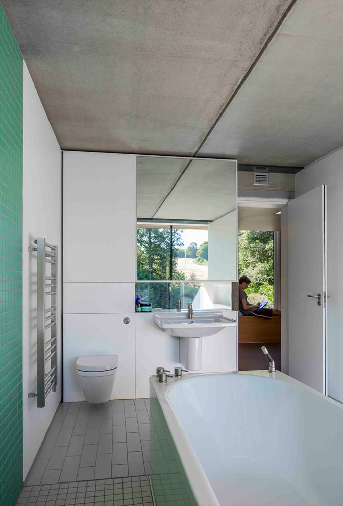 Großes Modernes Kinderbad mit Sockelwaschbecken, freistehender Badewanne, offener Dusche, Wandtoilette, grauen Fliesen, Keramikfliesen, grüner Wandfarbe und Keramikboden in London