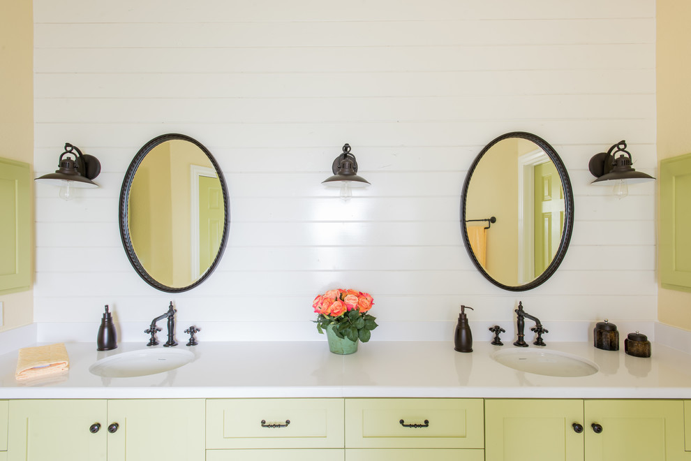 Idée de décoration pour une salle de bain champêtre avec un placard à porte shaker, des portes de placards vertess, un mur blanc et un lavabo encastré.