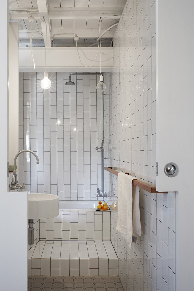 Idée de décoration pour une salle de bain urbaine avec une baignoire en alcôve, un combiné douche/baignoire, un carrelage blanc, un lavabo suspendu et un sol gris.