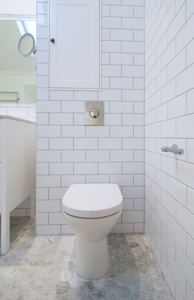 Idéer för ett stort klassiskt en-suite badrum, med luckor med profilerade fronter, vita skåp, ett fristående badkar, en kantlös dusch, en toalettstol med hel cisternkåpa, vit kakel, porslinskakel, vita väggar, marmorgolv, ett undermonterad handfat och marmorbänkskiva
