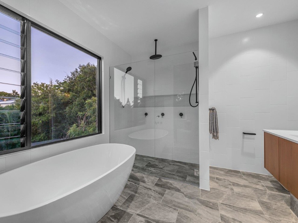 Imagen de cuarto de baño principal minimalista grande con bañera exenta, baldosas y/o azulejos blancos y encimeras blancas