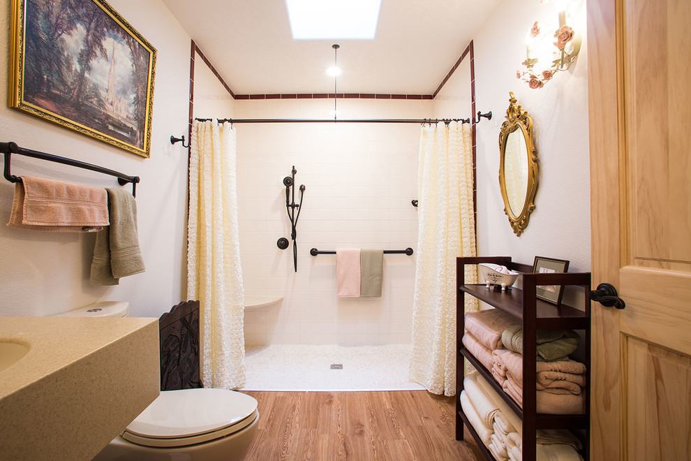 アルバカーキにある中くらいなトラディショナルスタイルのおしゃれなバスルーム (浴槽なし) (バリアフリー、アンダーカウンター洗面器、無垢フローリング、オープンシェルフ、分離型トイレ、白いタイル、サブウェイタイル、白い壁、茶色い床、オープンシャワー) の写真