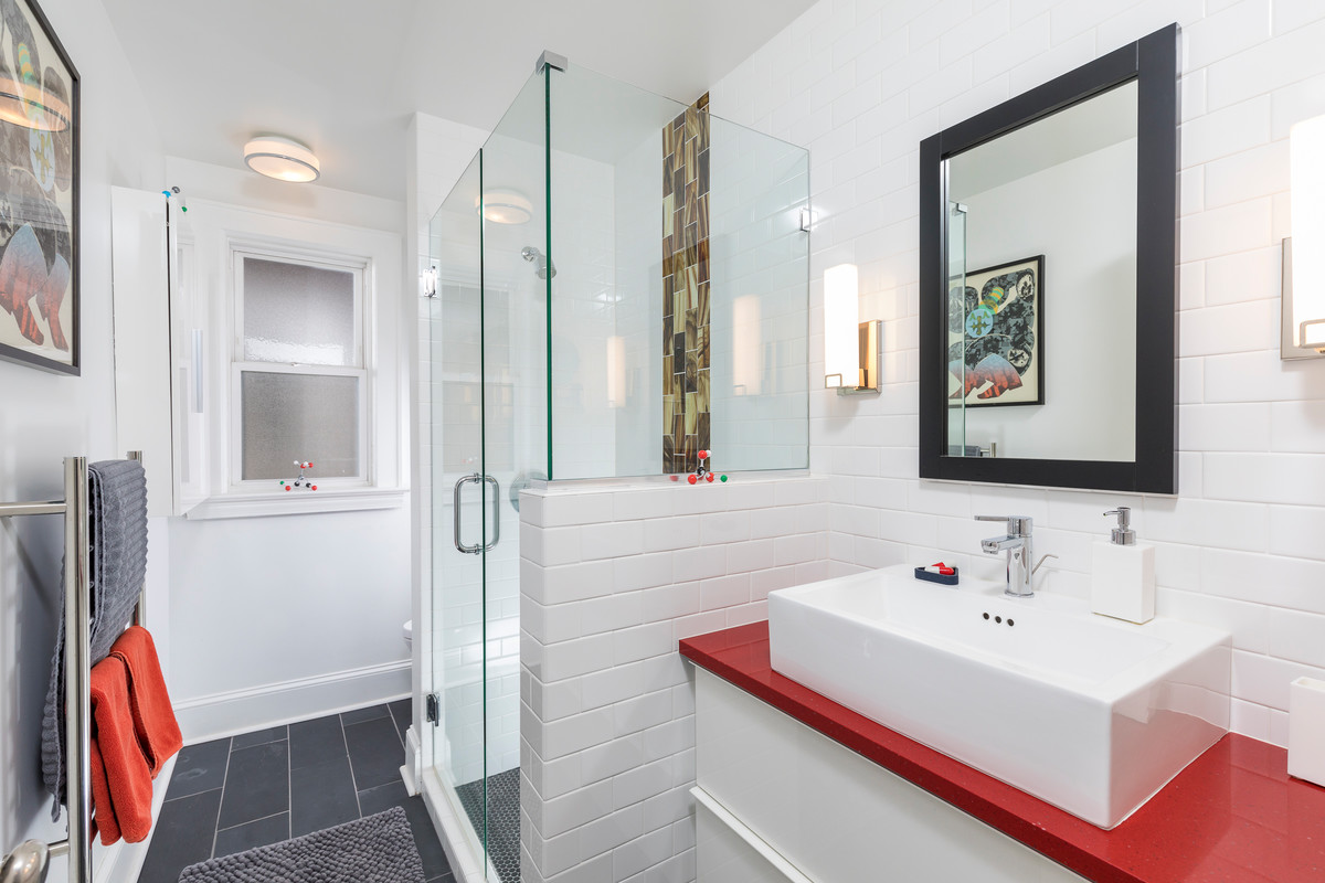 Réalisation d'une salle de bain design de taille moyenne avec des portes de placard blanches, un carrelage blanc, un carrelage métro, un mur blanc, un sol en ardoise, une vasque, un sol gris et une cabine de douche à porte battante.