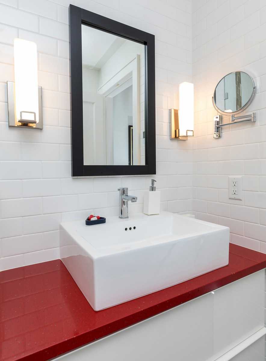 Example of a mid-sized trendy 3/4 white tile and subway tile slate floor and gray floor alcove shower design in Minneapolis with white cabinets, white walls, a vessel sink and a hinged shower door