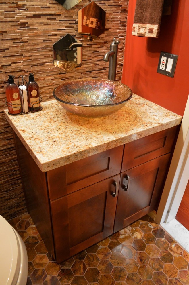 Réalisation d'une petite salle d'eau tradition en bois brun avec une vasque, un placard à porte shaker, un plan de toilette en granite, WC séparés, un mur rouge, un sol en carrelage de terre cuite et un carrelage marron.