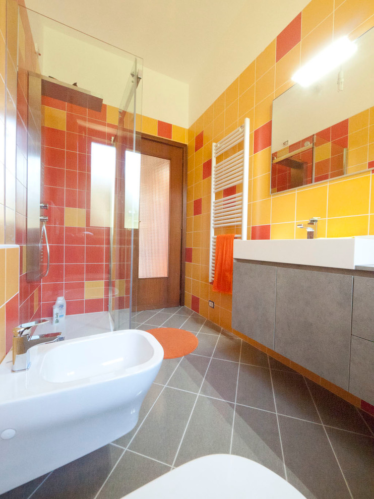 Источник вдохновения для домашнего уюта: главная ванная комната среднего размера в стиле модернизм с плоскими фасадами, серыми фасадами, столешницей из ламината, угловым душем, раздельным унитазом, оранжевой плиткой, керамической плиткой, консольной раковиной, оранжевыми стенами и полом из керамической плитки