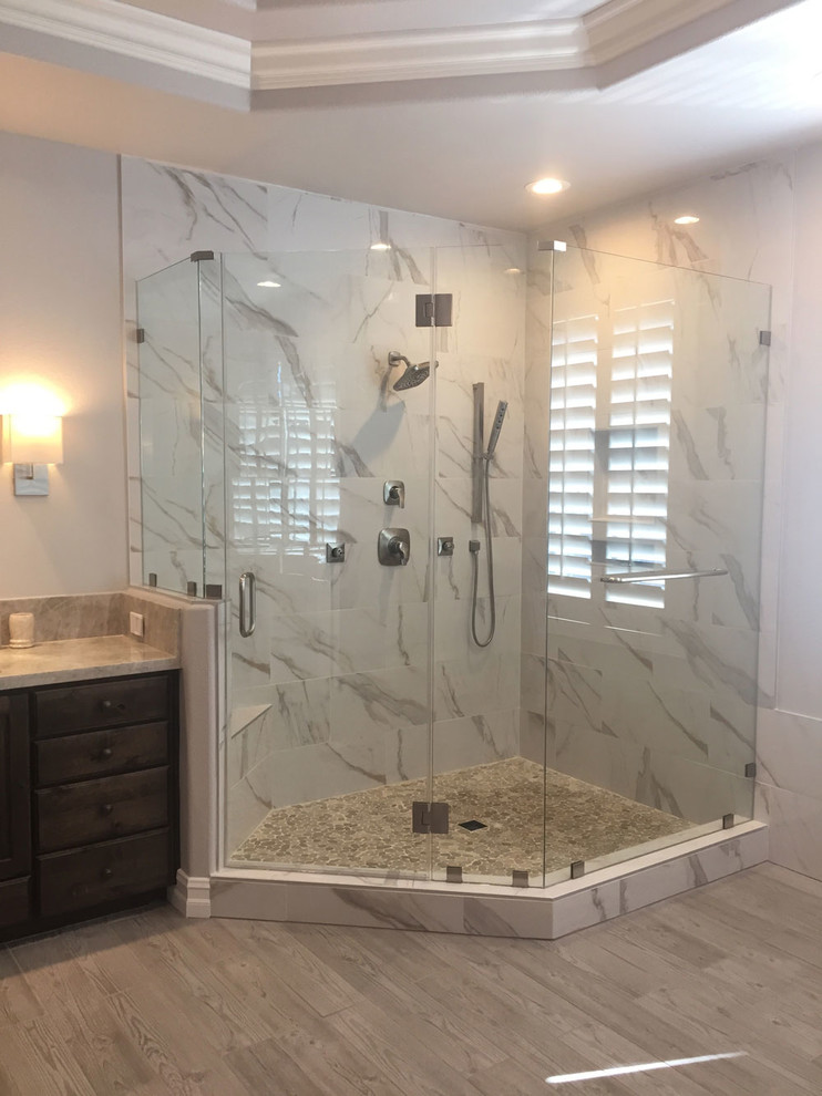 Inspiration for a huge transitional master gray tile and porcelain tile porcelain tile and gray floor bathroom remodel in Las Vegas with raised-panel cabinets, brown cabinets, a bidet, gray walls, a vessel sink, granite countertops and a hinged shower door