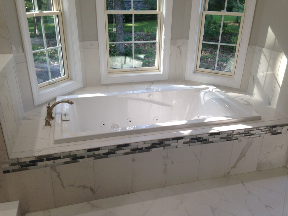 Klassisk inredning av ett mellanstort en-suite badrum, med luckor med upphöjd panel, svarta skåp, ett badkar i en alkov, en dusch i en alkov, porslinskakel, grå väggar, klinkergolv i porslin, ett undermonterad handfat och granitbänkskiva