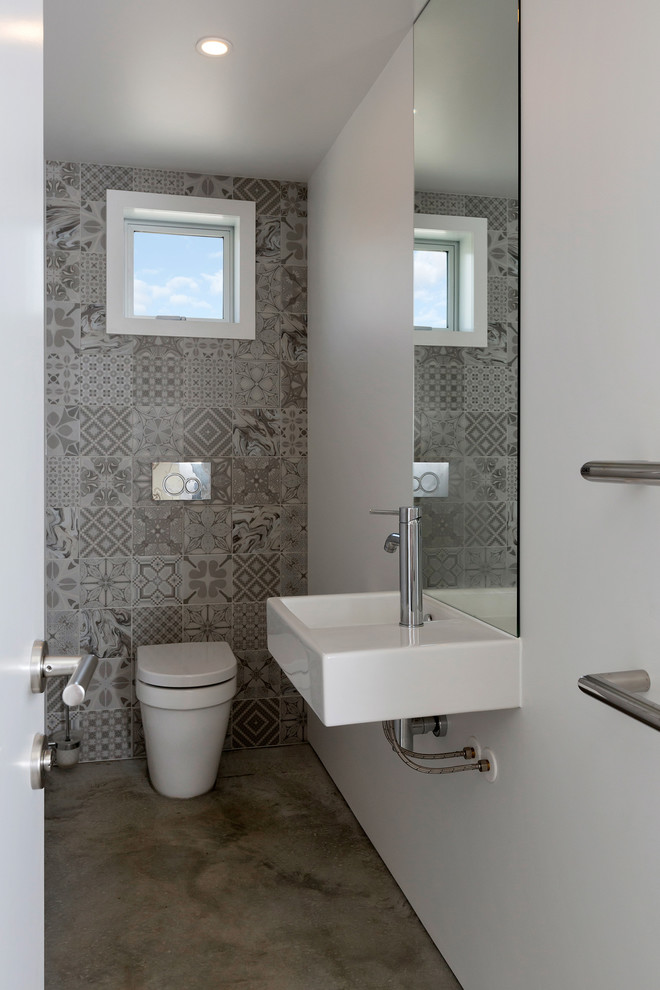 Foto de cuarto de baño contemporáneo pequeño con baldosas y/o azulejos grises, baldosas y/o azulejos de cerámica, paredes blancas, suelo de cemento, aseo y ducha, lavabo suspendido, suelo gris y encimeras blancas