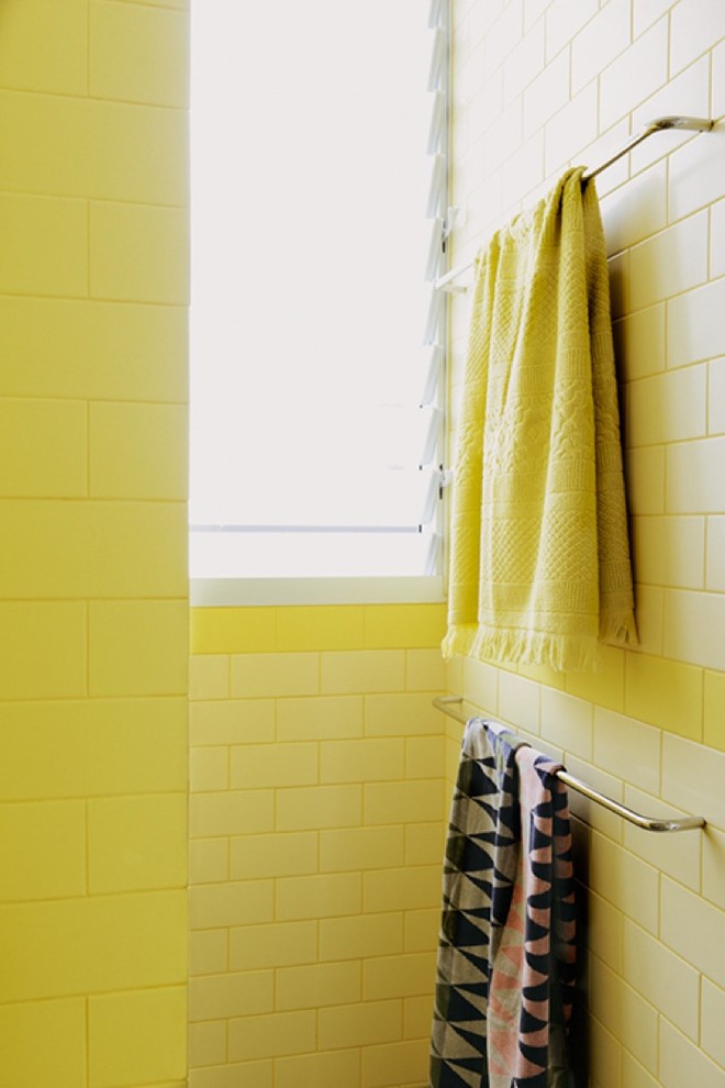 シドニーにあるお手頃価格の小さなモダンスタイルのおしゃれな浴室 (壁付け型シンク、フラットパネル扉のキャビネット、タイルの洗面台、アルコーブ型シャワー、壁掛け式トイレ、黄色いタイル、セラミックタイル、黄色い壁、セラミックタイルの床) の写真