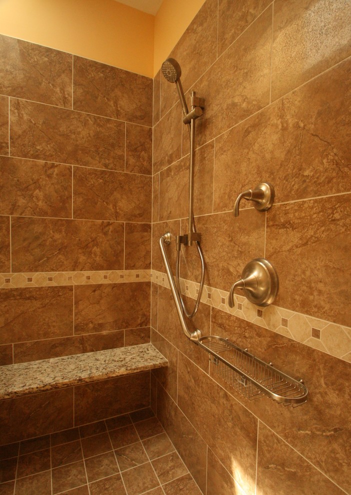 Klassisk inredning av ett badrum, med en dusch i en alkov, gula väggar och klinkergolv i keramik