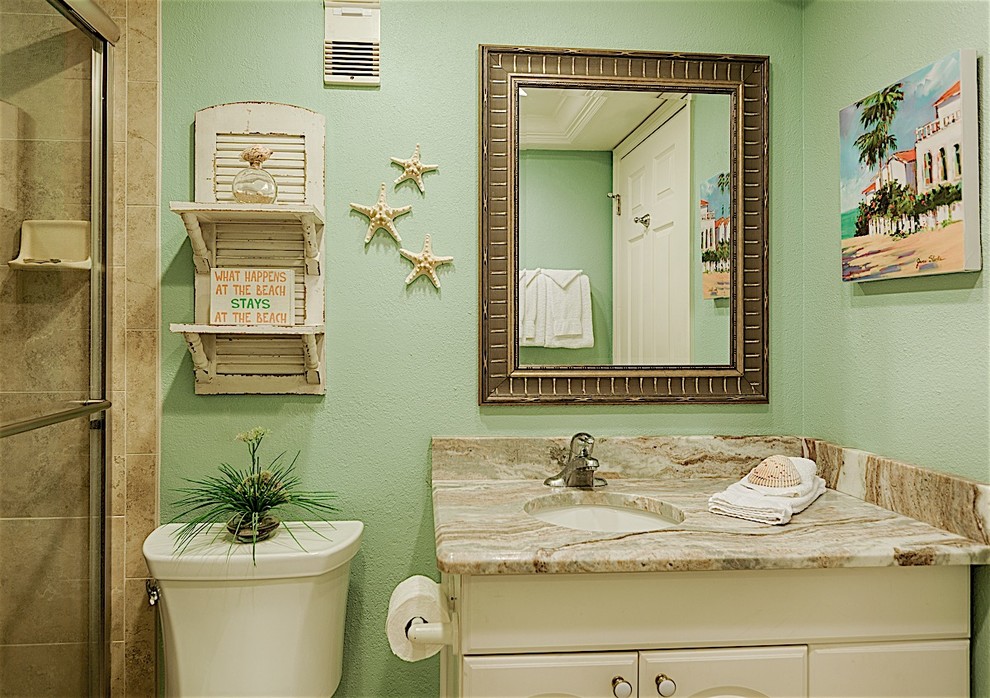 Photo of a small coastal family bathroom in Tampa with raised-panel cabinets, white cabinets, a built-in bath, a two-piece toilet, beige tiles, ceramic tiles, beige walls, ceramic flooring, a submerged sink and granite worktops.