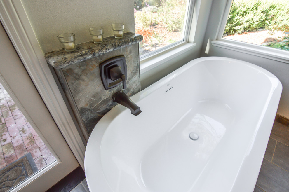 Bild på ett stort eklektiskt flerfärgad flerfärgat en-suite badrum, med luckor med infälld panel, skåp i mörkt trä, ett fristående badkar, en öppen dusch, flerfärgad kakel, stenkakel, beige väggar, klinkergolv i porslin, ett undermonterad handfat, granitbänkskiva, grått golv och med dusch som är öppen