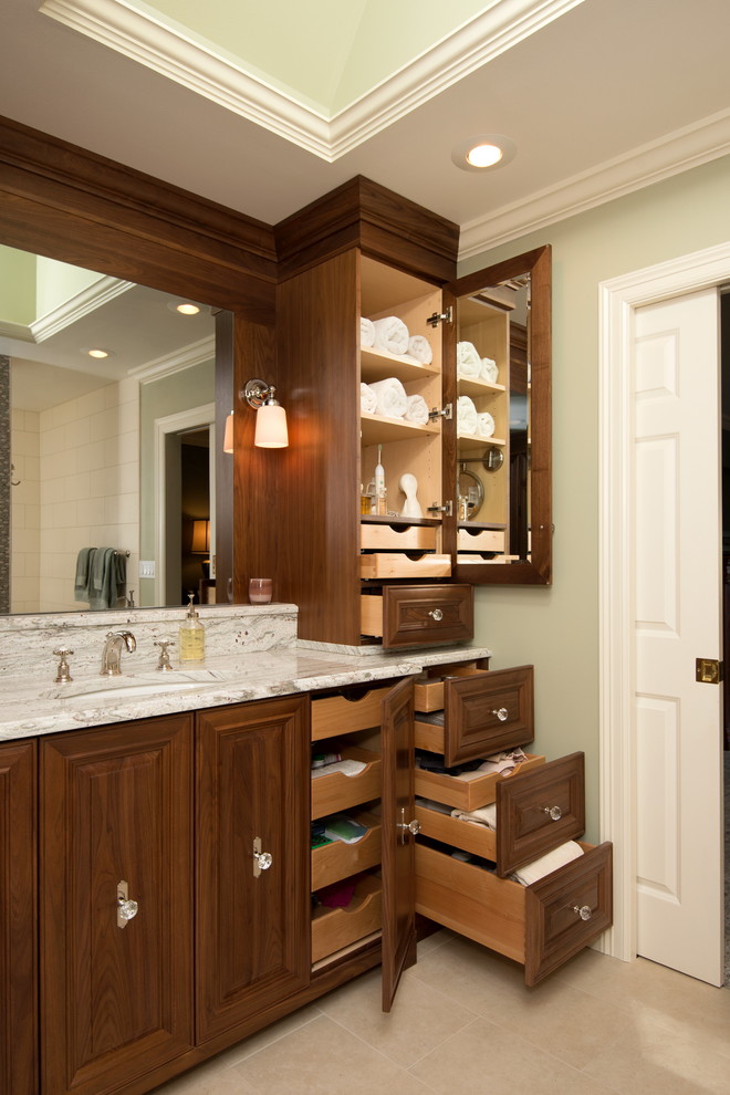 Foto de cuarto de baño rectangular tradicional con armarios con paneles con relieve y puertas de armario de madera en tonos medios