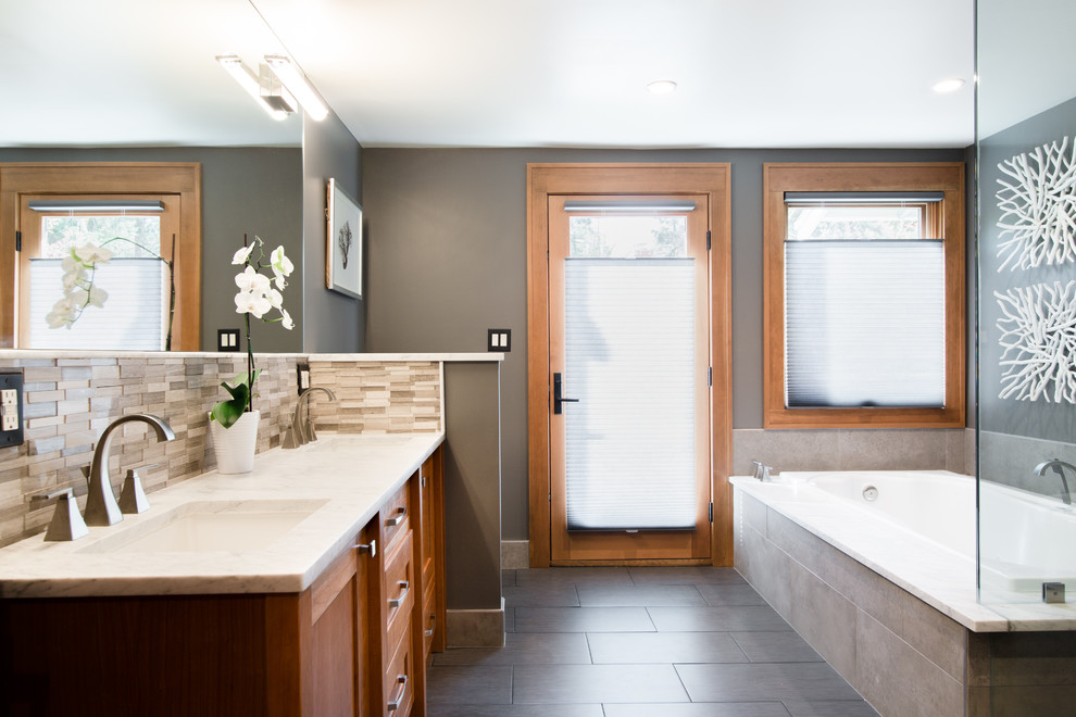 Exempel på ett mellanstort klassiskt en-suite badrum, med skåp i shakerstil, skåp i mellenmörkt trä, ett platsbyggt badkar, en toalettstol med hel cisternkåpa, grå kakel, stenkakel, grå väggar, klinkergolv i keramik, ett undermonterad handfat, granitbänkskiva och grått golv