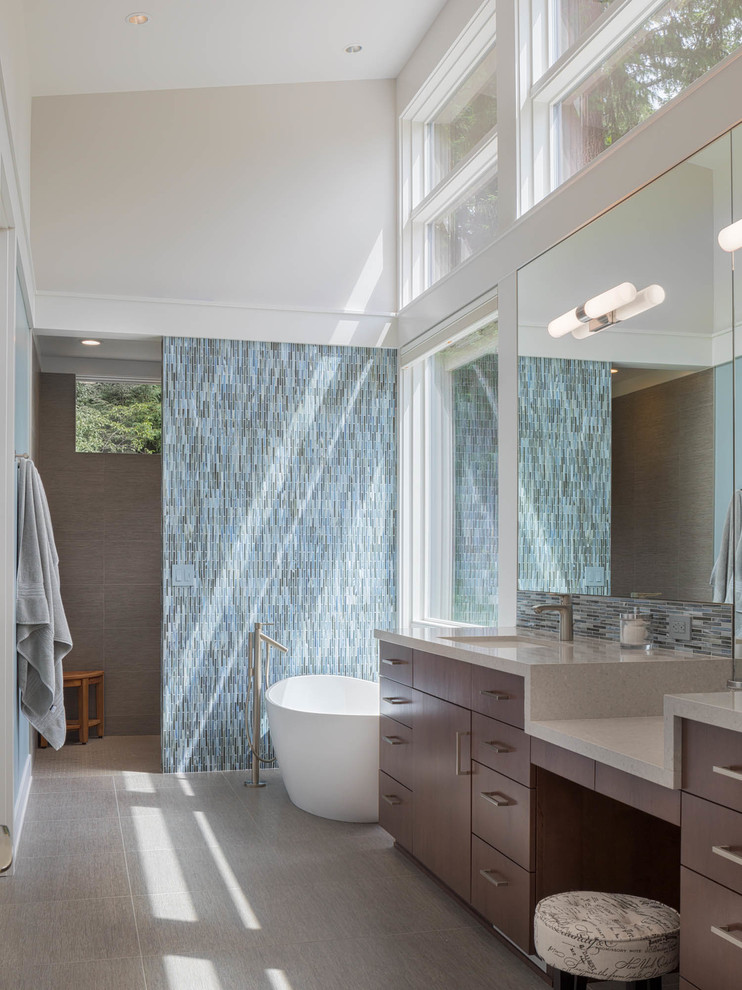 Идея дизайна: ванная комната в современном стиле с плоскими фасадами, темными деревянными фасадами, отдельно стоящей ванной, серыми стенами, врезной раковиной, серым полом и серой столешницей