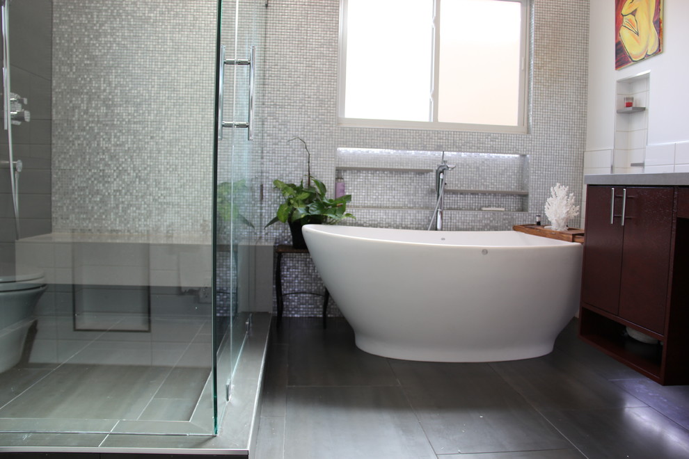 Идея дизайна: главная ванная комната среднего размера в современном стиле с фасадами островного типа, темными деревянными фасадами, отдельно стоящей ванной, угловым душем, белыми стенами, полом из сланца, врезной раковиной и столешницей из искусственного камня