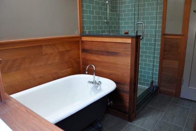 Imagen de cuarto de baño de estilo americano de tamaño medio con armarios estilo shaker, puertas de armario de madera oscura y aseo y ducha