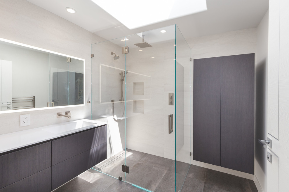 Idéer för små funkis vitt en-suite badrum, med släta luckor, grå skåp, en kantlös dusch, grå kakel, keramikplattor, vita väggar, cementgolv, ett integrerad handfat, grått golv och dusch med gångjärnsdörr