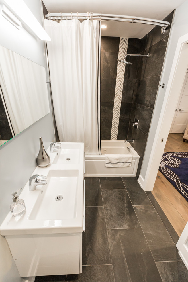 Aménagement d'une salle d'eau moderne de taille moyenne avec un placard avec porte à panneau encastré, des portes de placard blanches, une baignoire posée, un combiné douche/baignoire, un mur gris, un sol en carrelage de porcelaine, un lavabo posé, un sol noir, une cabine de douche avec un rideau, WC séparés et un plan de toilette blanc.