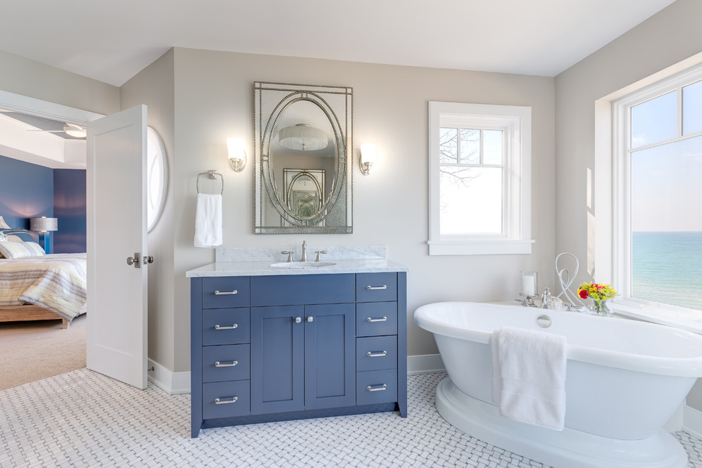 Design ideas for a nautical bathroom in Chicago with shaker cabinets, blue cabinets, a freestanding bath, a corner shower, yellow tiles, marble tiles, mosaic tile flooring, an integrated sink, marble worktops, white floors and a hinged door.