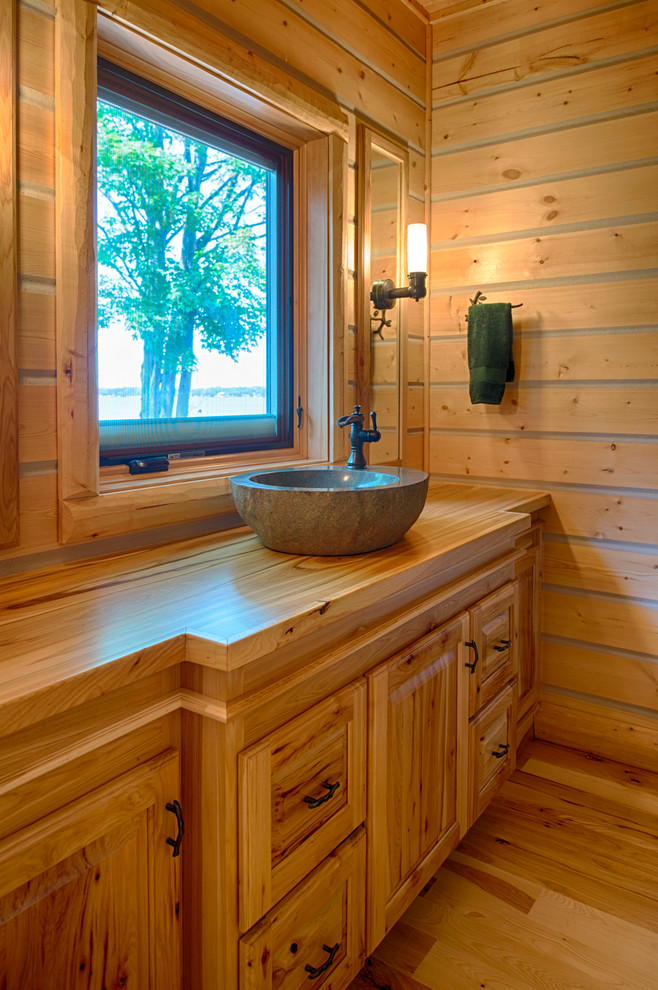 Exempel på ett rustikt brun brunt badrum, med ett fristående handfat, luckor med upphöjd panel, skåp i mellenmörkt trä och träbänkskiva
