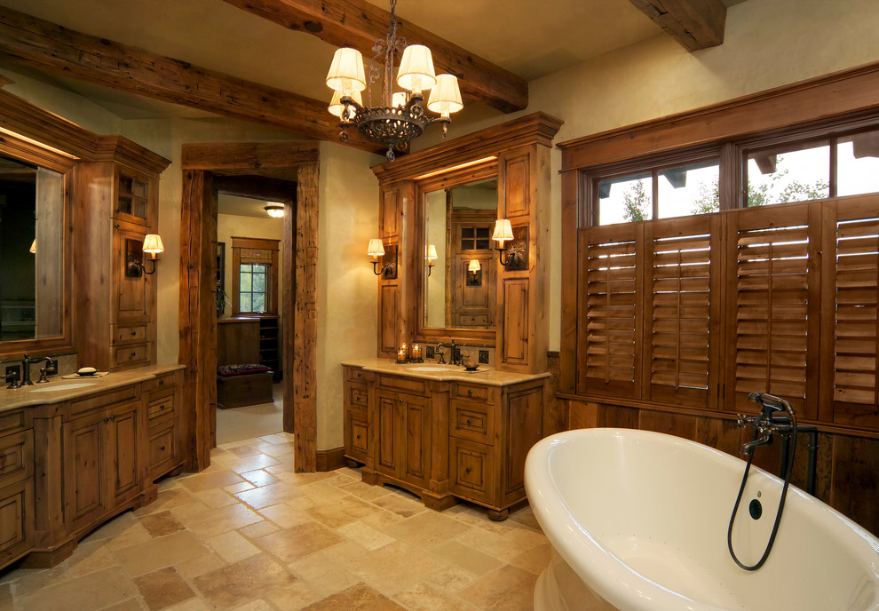 Idee per una grande stanza da bagno padronale rustica con ante con bugna sagomata, ante in legno scuro, vasca freestanding, pareti beige e lavabo sottopiano