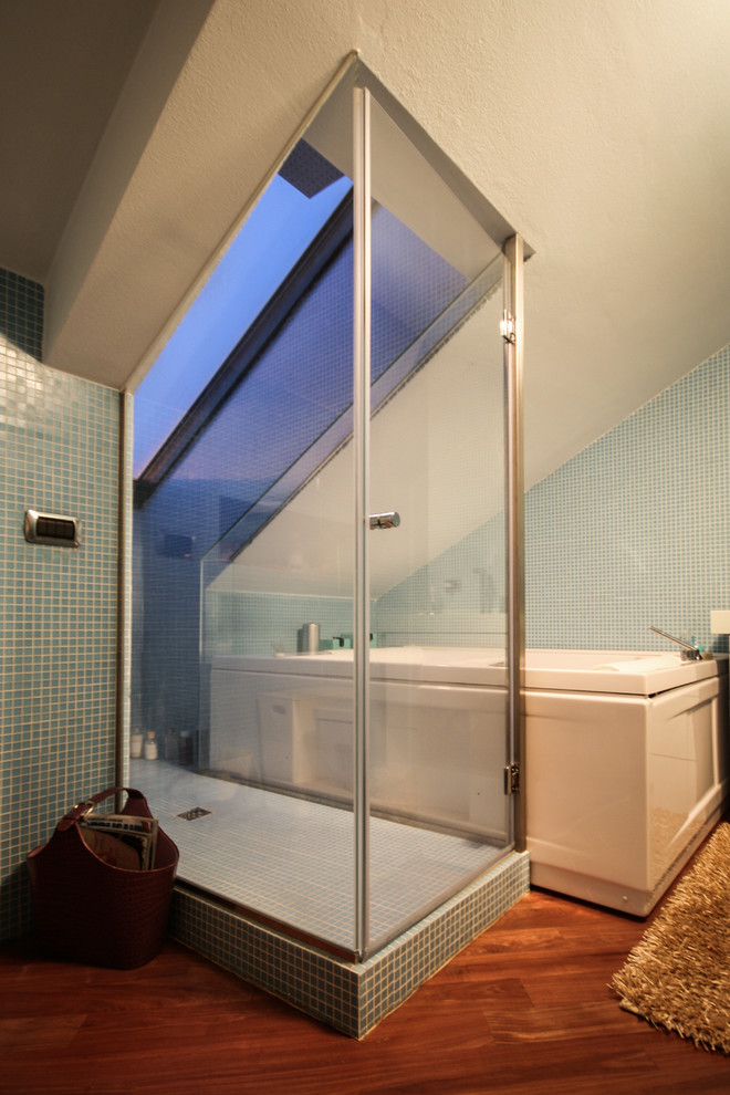 Esempio di una stanza da bagno padronale contemporanea con lavabo sospeso, ante blu, doccia aperta, WC a due pezzi, piastrelle blu, piastrelle a mosaico, pareti blu, pavimento in legno massello medio e vasca da incasso