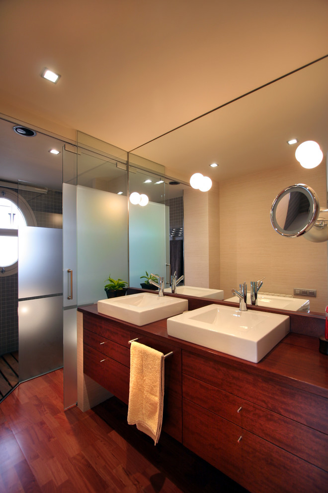 Foto di una stanza da bagno con doccia contemporanea di medie dimensioni con doccia a filo pavimento, pareti beige, parquet scuro e lavabo a bacinella