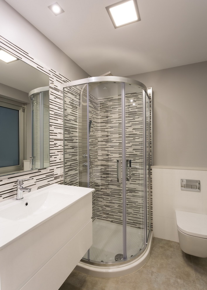 Mittelgroßes Modernes Duschbad mit flächenbündigen Schrankfronten, weißen Schränken, Eckdusche, Wandtoilette, grauer Wandfarbe und integriertem Waschbecken in Sonstige