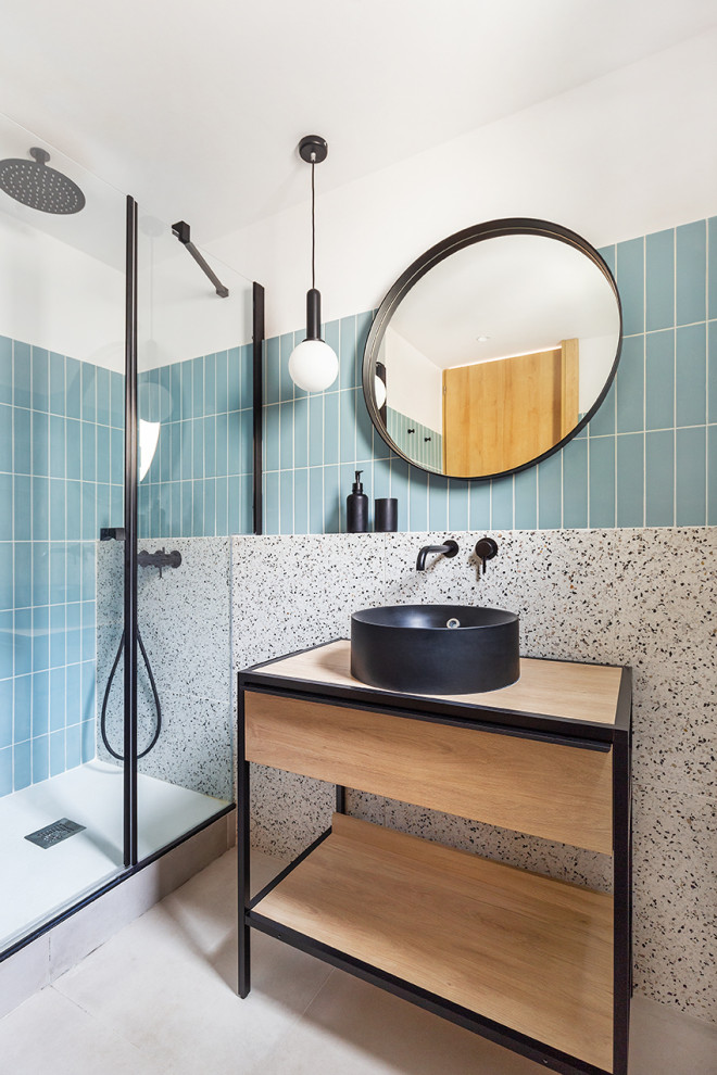 Idéer för ett modernt badrum, med öppna hyllor, skåp i ljust trä, en dusch i en alkov, blå kakel, vita väggar, ett fristående handfat, träbänkskiva, grått golv och dusch med gångjärnsdörr