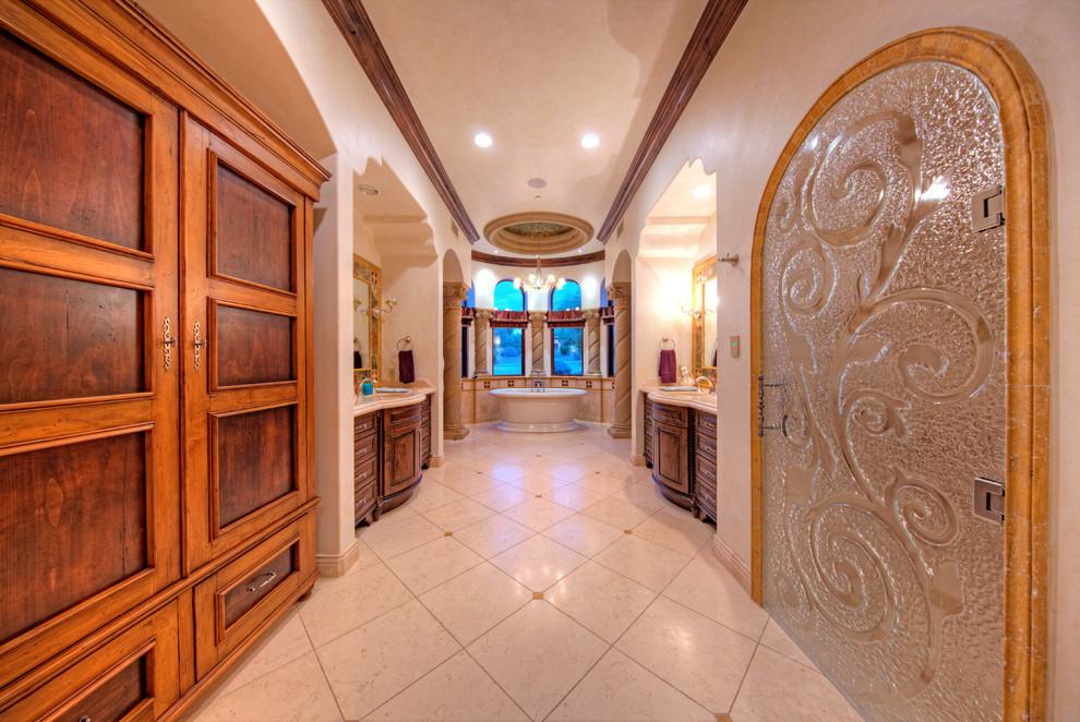 Imagen de cuarto de baño principal mediterráneo extra grande con armarios con paneles con relieve, puertas de armario de madera en tonos medios y bañera exenta