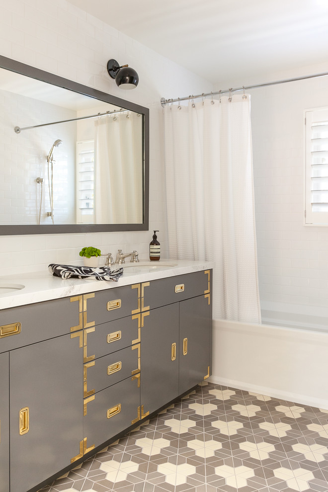 Imagen de cuarto de baño infantil clásico renovado de tamaño medio con puertas de armario grises, bañera empotrada, combinación de ducha y bañera, baldosas y/o azulejos blancos, baldosas y/o azulejos de cerámica, suelo de baldosas de cerámica, lavabo bajoencimera, encimera de cuarcita, ducha con cortina, encimeras blancas, armarios con paneles lisos, paredes blancas y suelo multicolor