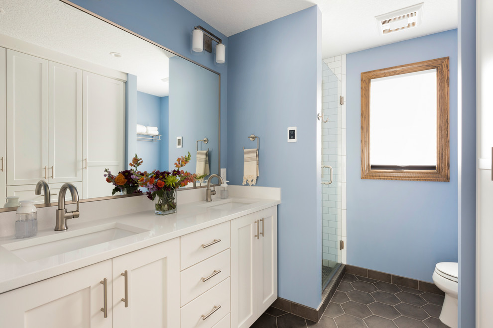 Aménagement d'une petite douche en alcôve principale classique avec un placard à porte shaker, des portes de placard blanches, WC séparés, un carrelage blanc, un carrelage métro, un mur bleu, un sol en carrelage de porcelaine, un lavabo encastré, un plan de toilette en quartz modifié, un sol gris et une cabine de douche à porte battante.