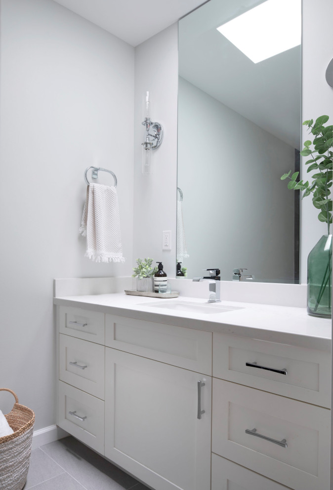Idéer för att renovera ett mellanstort vintage vit vitt badrum, med skåp i shakerstil, grå skåp, ett badkar i en alkov, en dusch/badkar-kombination, en toalettstol med separat cisternkåpa, grå kakel, porslinskakel, vita väggar, klinkergolv i porslin, ett undermonterad handfat, bänkskiva i kvarts, grått golv och dusch med skjutdörr