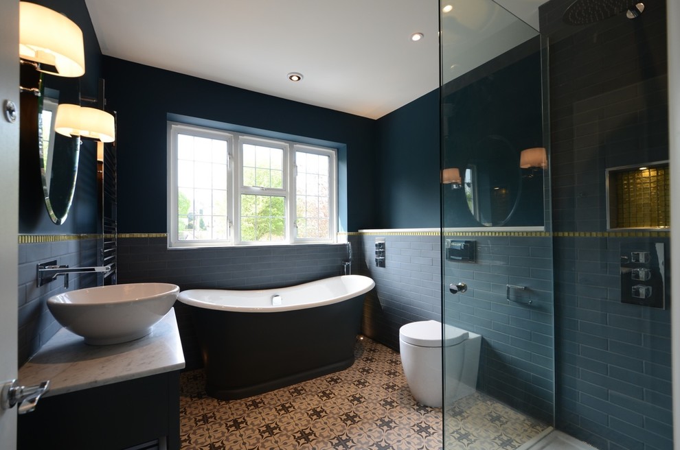 Design ideas for a medium sized eclectic bathroom in Sussex with shaker cabinets, blue cabinets, a freestanding bath, a walk-in shower, a one-piece toilet, blue tiles, ceramic tiles, blue walls, ceramic flooring, a console sink and marble worktops.