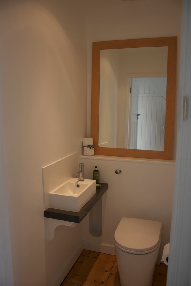 Kleine Moderne Gästetoilette mit hellem Holzboden in Sonstige
