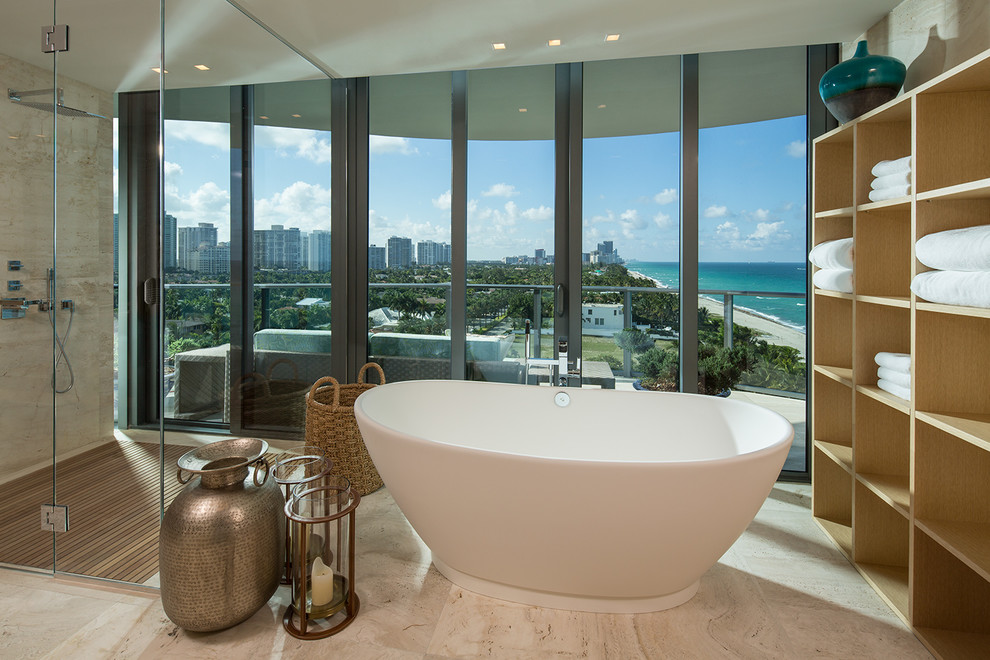 Cette image montre une salle de bain design avec une baignoire indépendante, une douche d'angle et un carrelage beige.