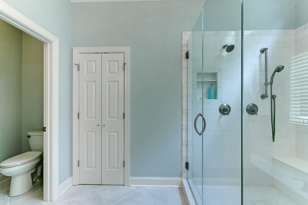 Large contemporary ensuite bathroom in Raleigh with recessed-panel cabinets, white cabinets, a submerged bath, a corner shower, a two-piece toilet, blue walls, porcelain flooring, a submerged sink, solid surface worktops, grey floors, a hinged door and an enclosed toilet.