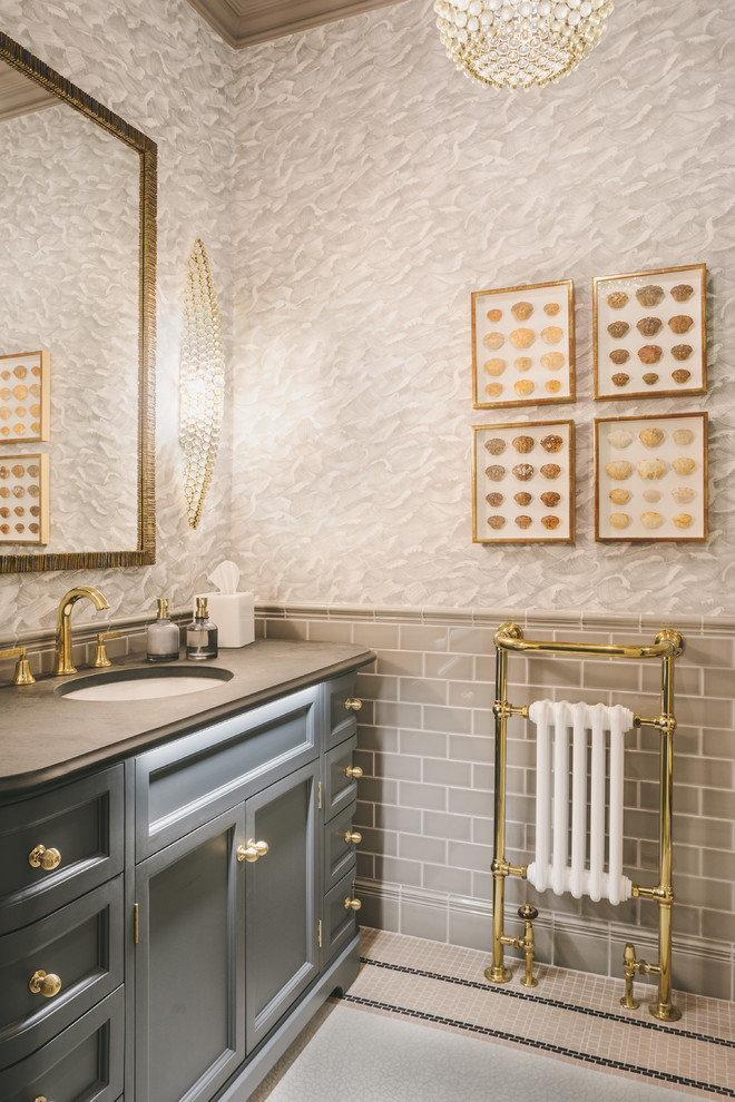 Foto på ett mellanstort vintage grå badrum, med blå skåp, grå kakel, tunnelbanekakel, flerfärgade väggar, ett undermonterad handfat, flerfärgat golv och luckor med infälld panel