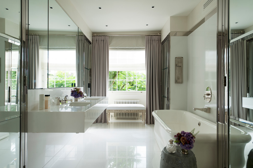 Modelo de cuarto de baño tradicional con lavabo suspendido, bañera exenta y baldosas y/o azulejos blancos