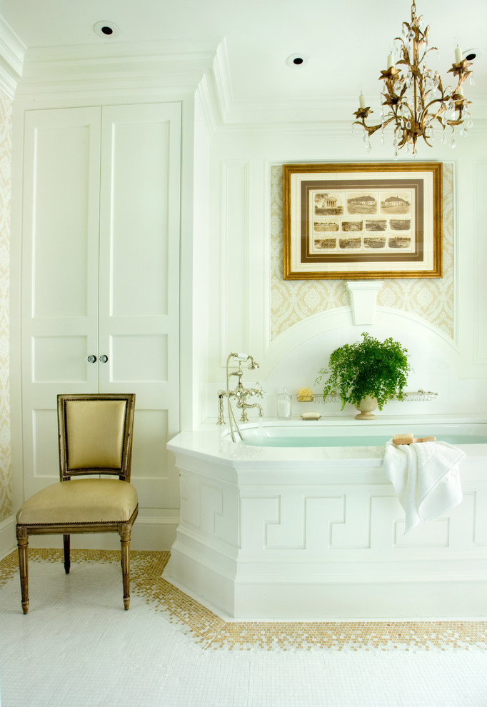 Inredning av ett klassiskt badrum, med vita skåp och ett undermonterat badkar