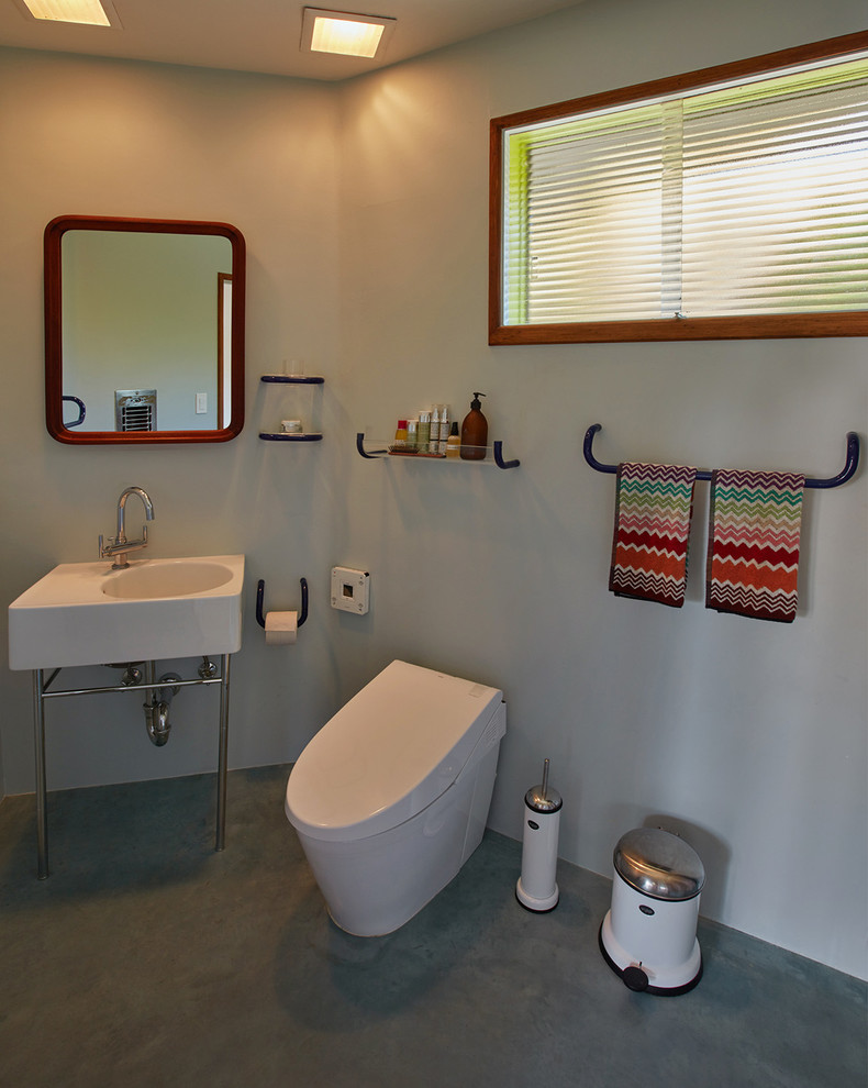 Diseño de cuarto de baño principal retro con paredes azules, lavabo con pedestal y suelo azul