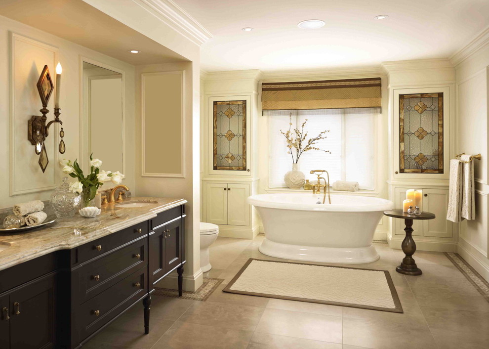 Inspiration for a large timeless master travertine floor freestanding bathtub remodel in Toronto with recessed-panel cabinets, dark wood cabinets, beige walls, an undermount sink and granite countertops