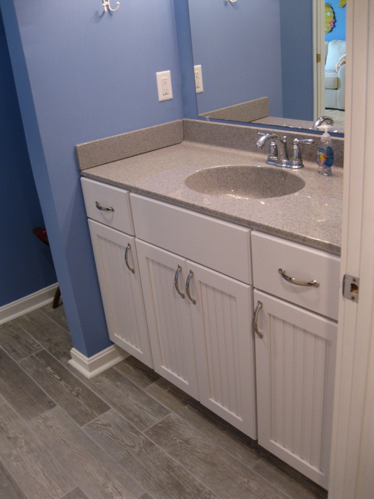 Esempio di una stanza da bagno con doccia stile marinaro di medie dimensioni con ante a persiana, ante bianche, parquet scuro e lavabo integrato