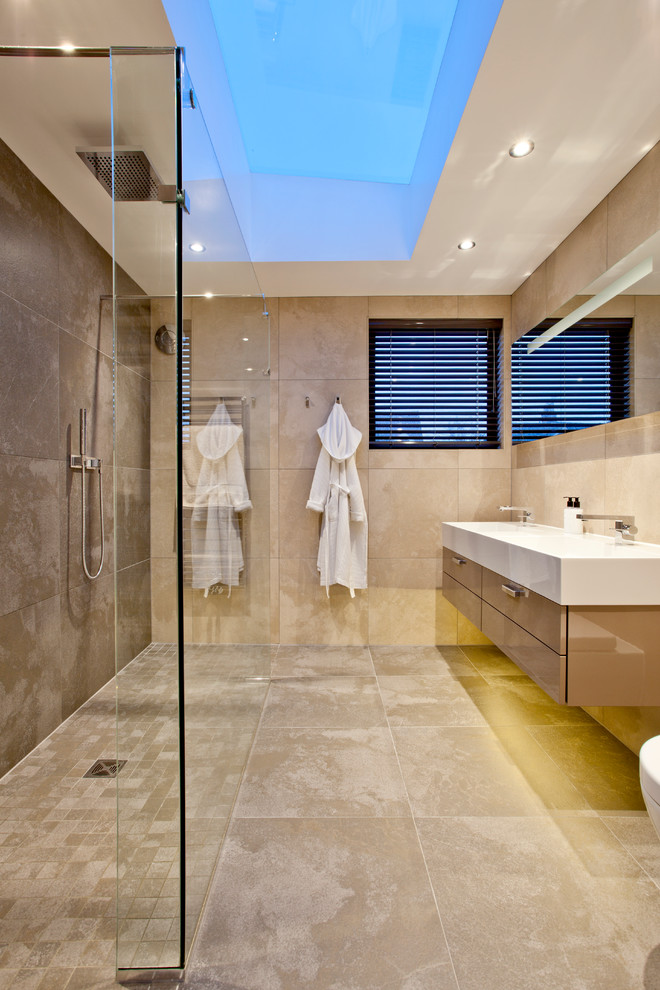 Exempel på ett modernt badrum, med ett konsol handfat, släta luckor, beige skåp och beige kakel